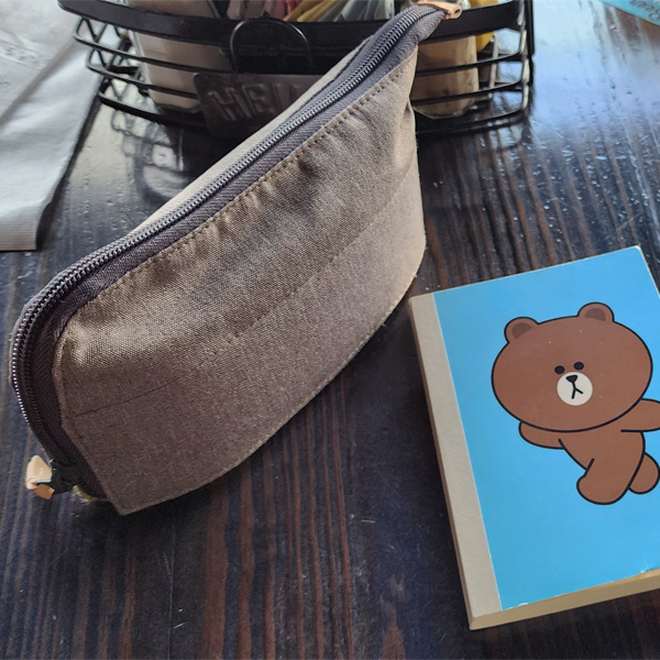 Small pouch and notebook on a restaurant table.